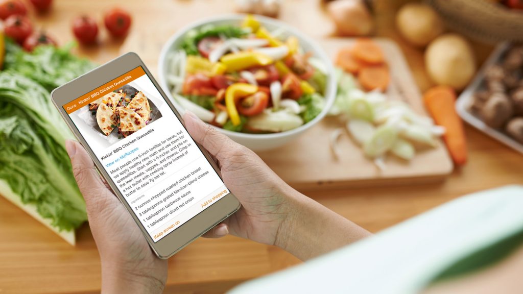 Person joyfully savoring a home-cooked meal prepared with the assistance of the meal planning app."