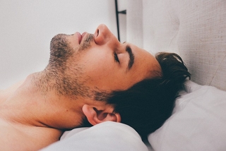 A person peacefully sleeping, embraced by a radiant aura symbolizing the prioritization of cherished memories during sleep."