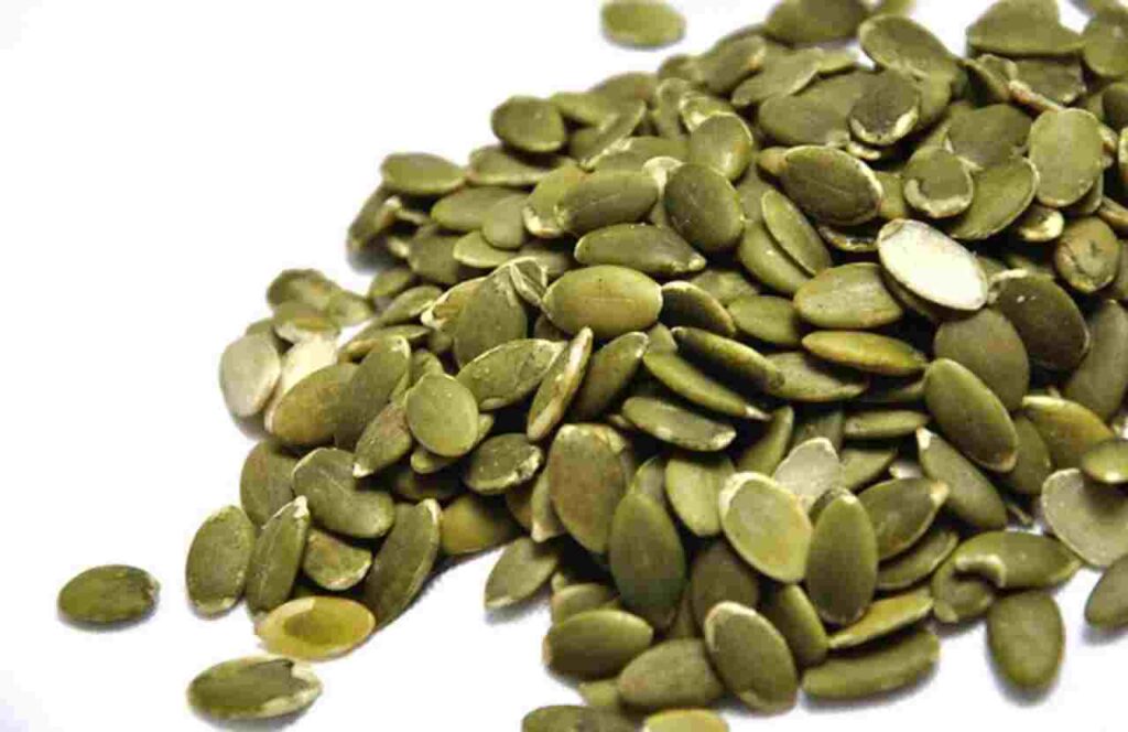 "Image of pumpkin seeds in a wooden bowl - Discover the health benefits!"