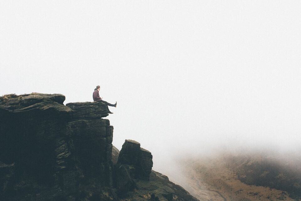 being brave "A person standing at the edge of a cliff, symbolizing bravery."