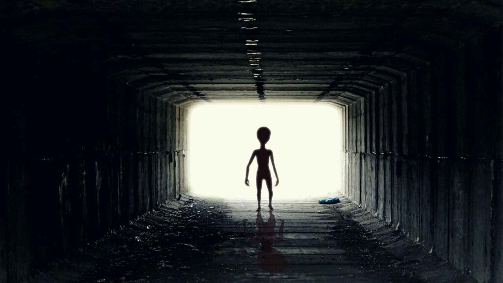 Illustration of a mysterious extraterrestrial silhouette against a starry background.