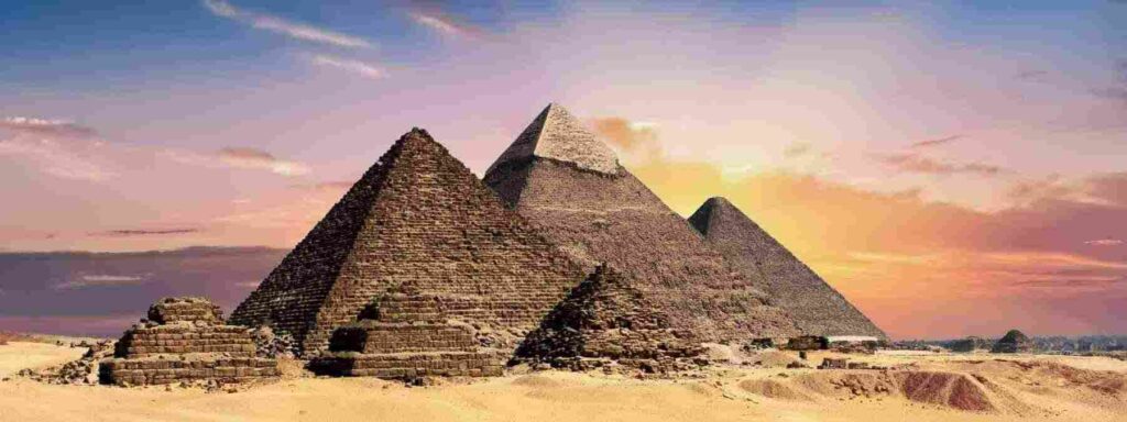 Awe-inspiring Egyptian Pyramids standing tall against a clear blue sky, showcasing the ancient architectural wonders of Egypt