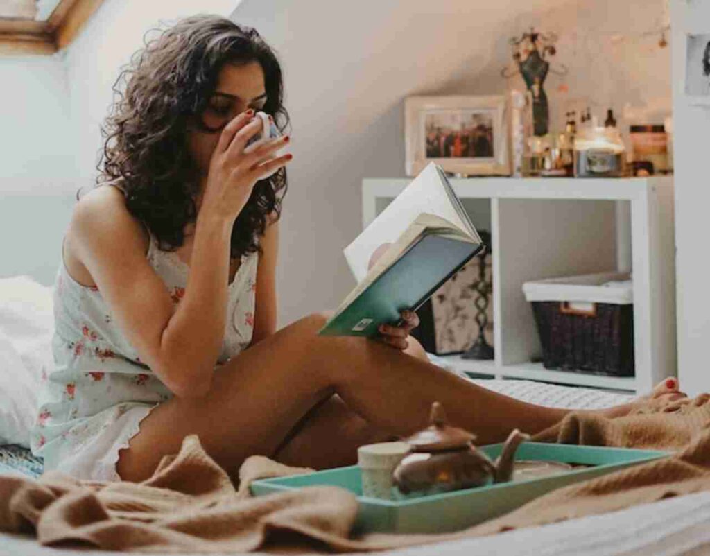 "A woman enjoying a peaceful moment with a cup of tea and a book."