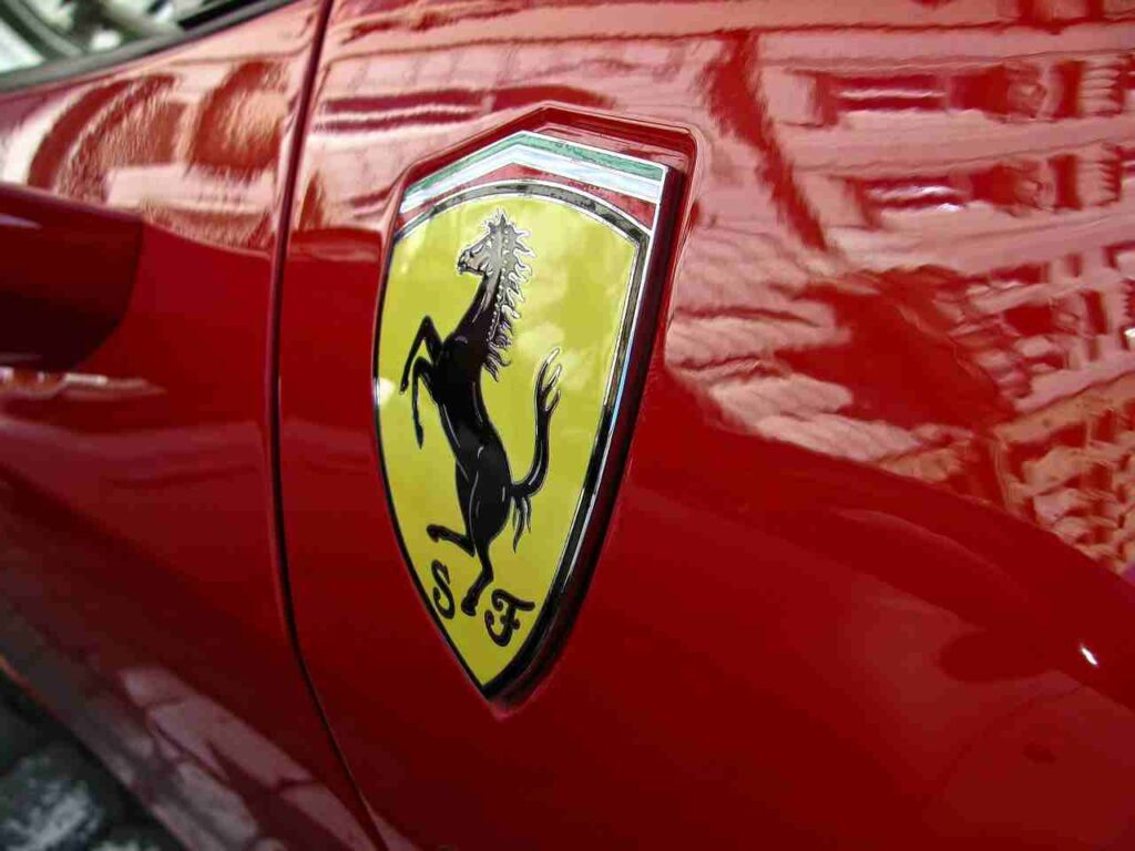 Ferrari sports car on a scenic road, representing automotive excellence.