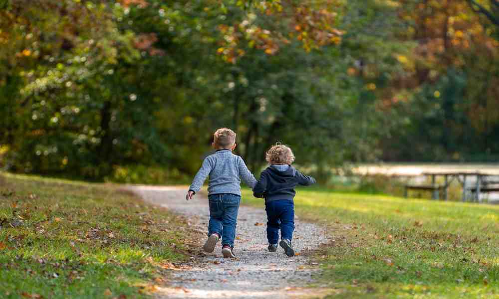 Happy kids running outdoors, learning to run faster with smiles on their faces.