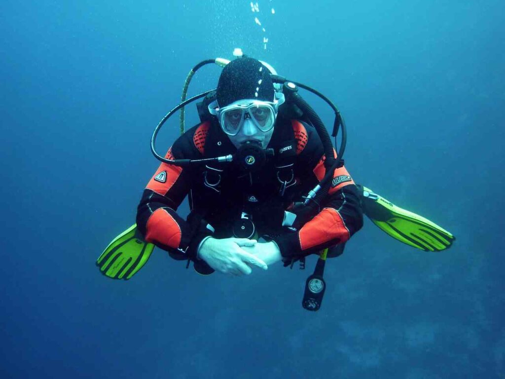 Diver exploring colorful coral reef with vibrant marine life underwater.