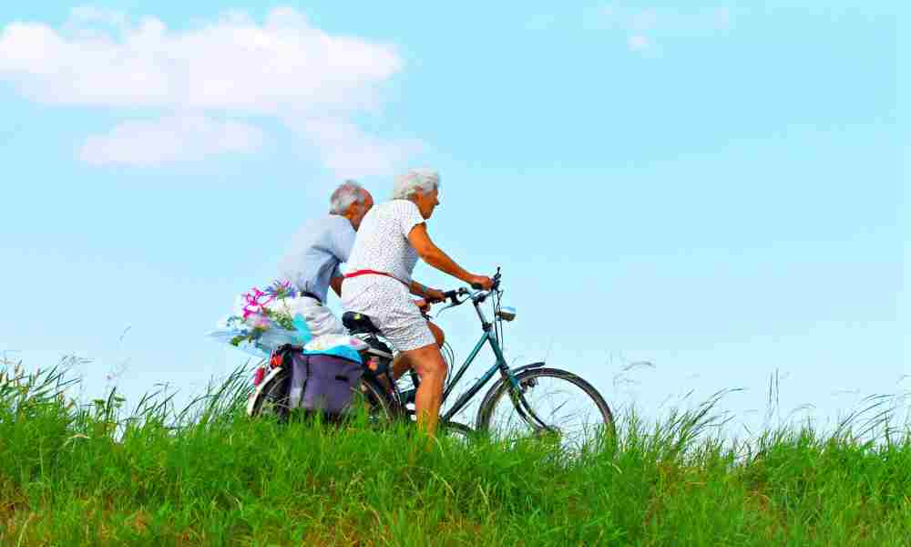 A person happily cycling through a scenic route, surrounded by nature and blue skies.