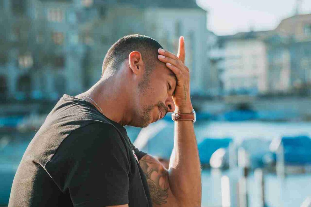 Woman holding her head in pain, experiencing a headache.
